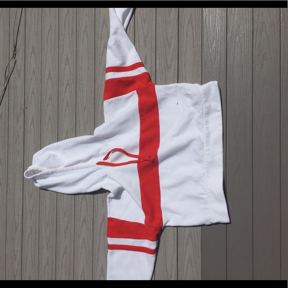 White cropped hoodie with red stripes.
